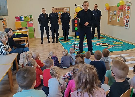 Policjant pokazuje przedszkolakom sygnalizator
