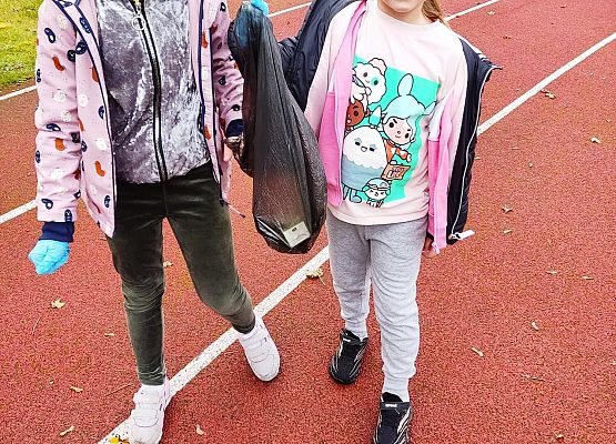 Dwie uczennice niosą worek na śmieci