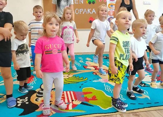 Przedszkolaki w strojach gimnastycznych ćwiczą