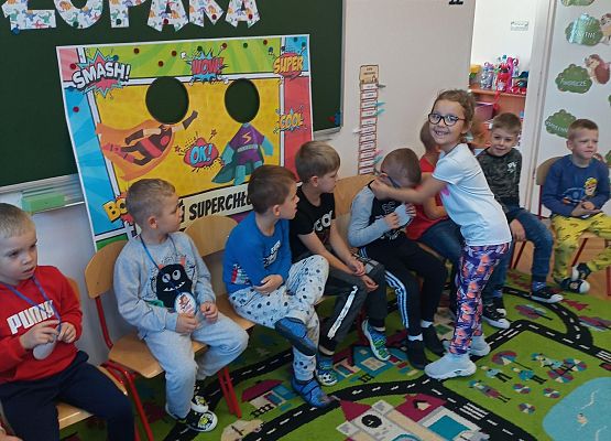 Dziewczynka wręcza chłopcu medal