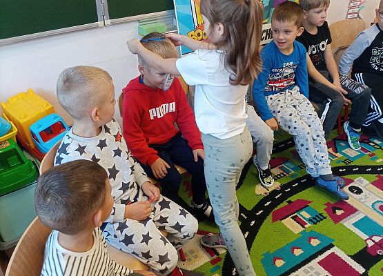 Dziewczynka wręcza chłopcu medal