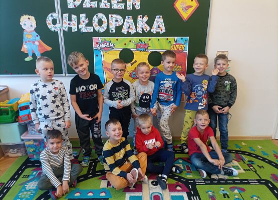 Wspólne zdjęcie chłopców przy tablicy z napisem dzień chłopaka