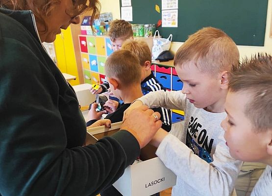 Nauczycielka wręcza chłopcom upominki