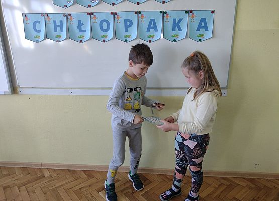 Uczennica wręcza koledze upominek i dyplom