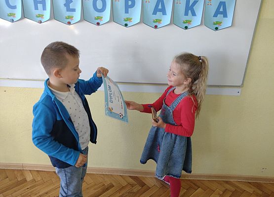 Uczennica wręcza koledze upominek i dyplom