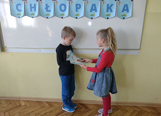 Uczennica wręcza koledze upominek i dyplom