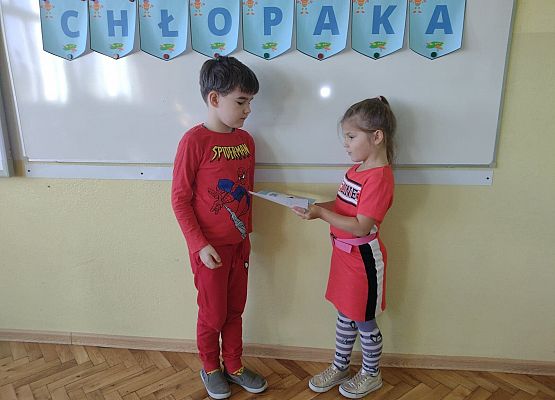 Uczennica wręcza koledze upominek i dyplom