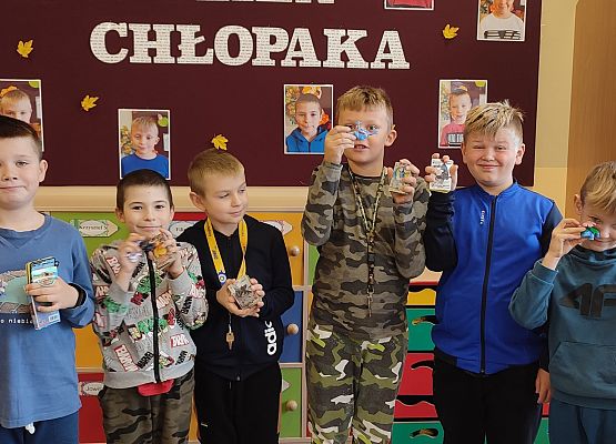 Chłopcy stoją i prezentują otrzymane upominki