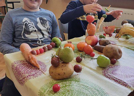 Dwaj uczniowie wykonują z warzyw jesienną pracę