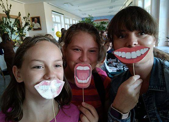 Nauczycielka z uczennicami uśmiechają się.