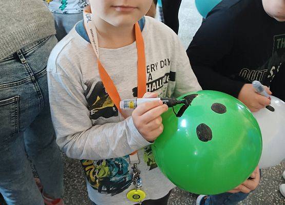 Uczeń prezentuje swoją balonową emotikonę