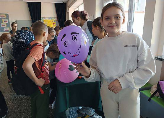 Uczennica prezentuje swoją balonową emotikonę..