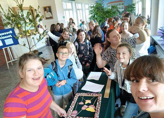 Uczniowie uśmiechnięci przy stoiskach z zabawami.