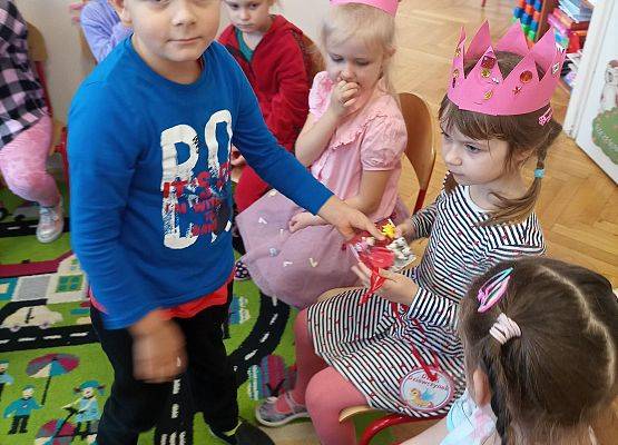 Chłopiec wręcza  dziewczynce upominki