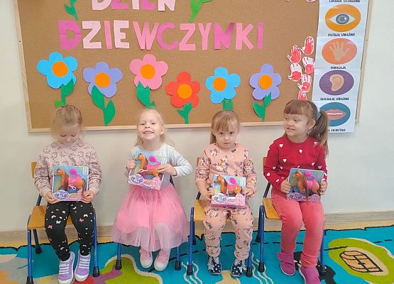 Uśmiechnięte dziewczynki prezentują otrzymane upominki