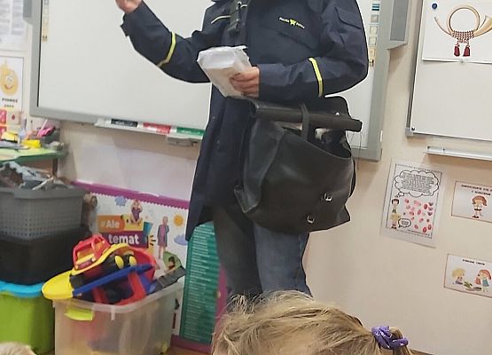 Listonosz opowiada o swojej pracy i pokazuje druki pocztowe