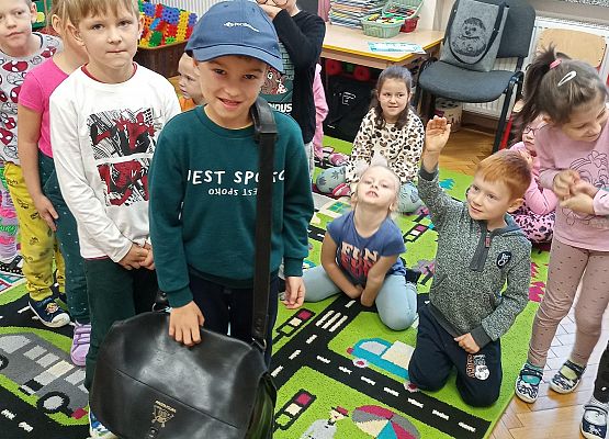 Chłopiec zakłada torbę listonosza