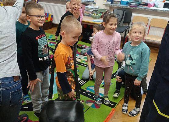 Chłopiec zakłada torbę listonosza