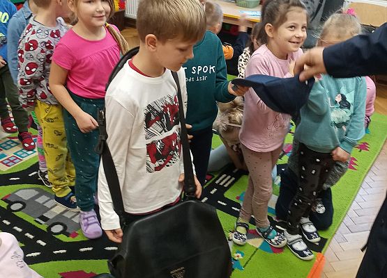 Chłopiec zakłada torbę listonosza