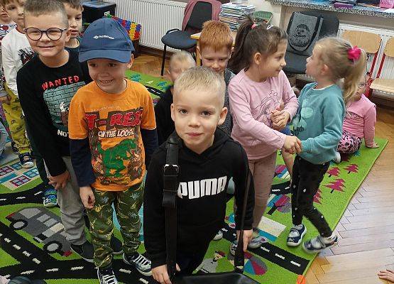 Chłopiec zakłada torbę listonosza