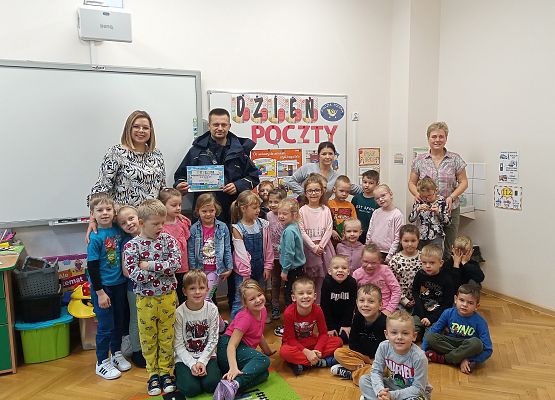 Zdjęcie grupowe przedszkolaków z listonoszem