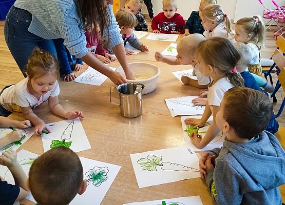 Nauczycielka wykonuje masę plastyczną, dzieci siedzą i się wpatrują