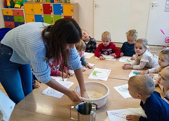 Nauczycielka zagniata w misce masę plastyczną