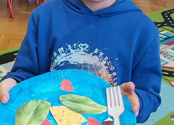 Chłopiec pokazuje swoją plastyczną pracę