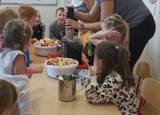 Nauczycielka robi w sokowirówce sok dla dzieci
