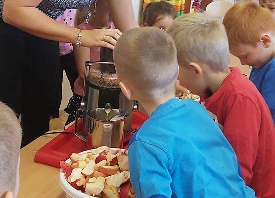 Nauczycielka robi w sokowirówce sok dla dzieci