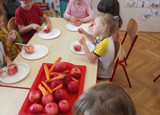 Dzieci przygotowują owoce do zrobienia soku