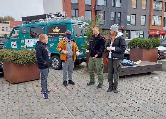 Uczniowie wykonują zadania podczas gry terenowej.