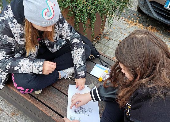 Uczniowie wykonują zadania podczas gry terenowej.