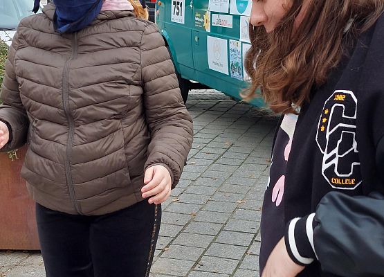 Uczniowie wykonują zadania podczas gry terenowej.