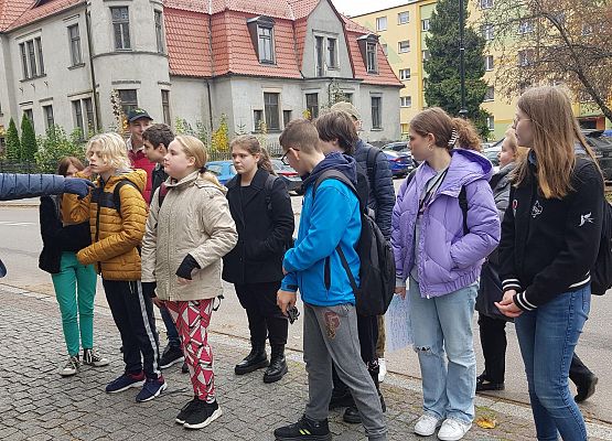 Uczniowie wykonują zadania podczas gry terenowej.