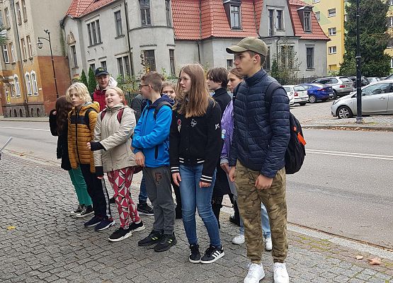 Uczniowie wykonują zadania podczas gry terenowej.