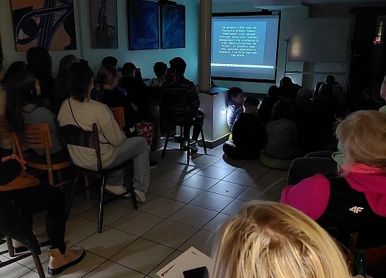 Uczniowie wykonują zadania podczas gry terenowej.