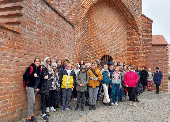 Uczniowie wykonują zadania podczas gry terenowej.