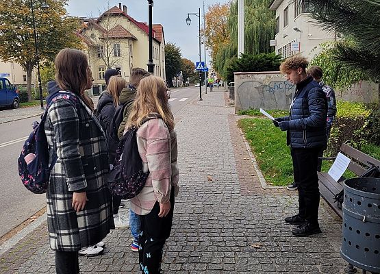 Uczniowie wykonują zadania podczas gry terenowej.