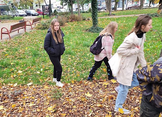 Uczniowie wykonują zadania podczas gry terenowej.