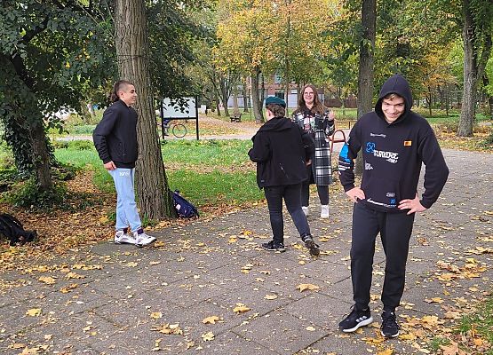 Uczniowie wykonują zadania podczas gry terenowej.