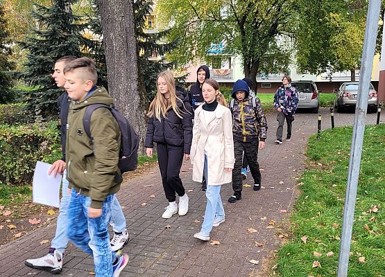 Uczniowie wykonują zadania podczas gry terenowej.