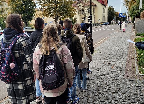 Uczniowie wykonują zadania podczas gry terenowej.
