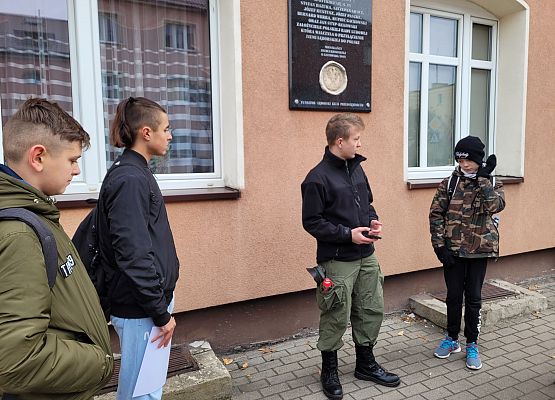 Uczniowie wykonują zadania podczas gry terenowej.