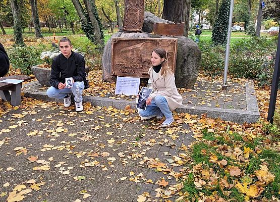 Uczniowie wykonują zadania podczas gry terenowej.