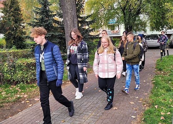 Uczniowie wykonują zadania podczas gry terenowej.