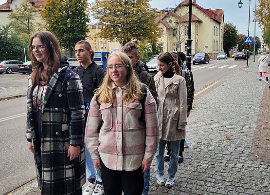 Uczniowie wykonują zadania podczas gry terenowej.