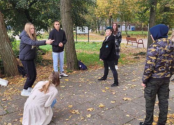 Uczniowie wykonują zadania podczas gry terenowej.