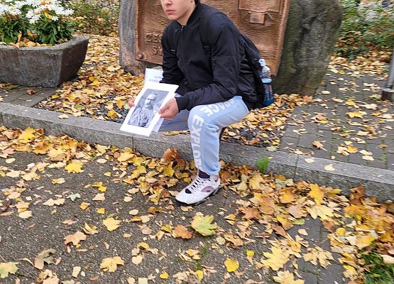 Uczniowie wykonują zadania podczas gry terenowej.