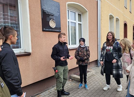 Uczniowie wykonują zadania podczas gry terenowej.